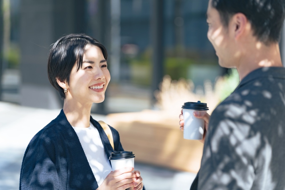 カフェで互いの表情を見ながら会話する日本人男女