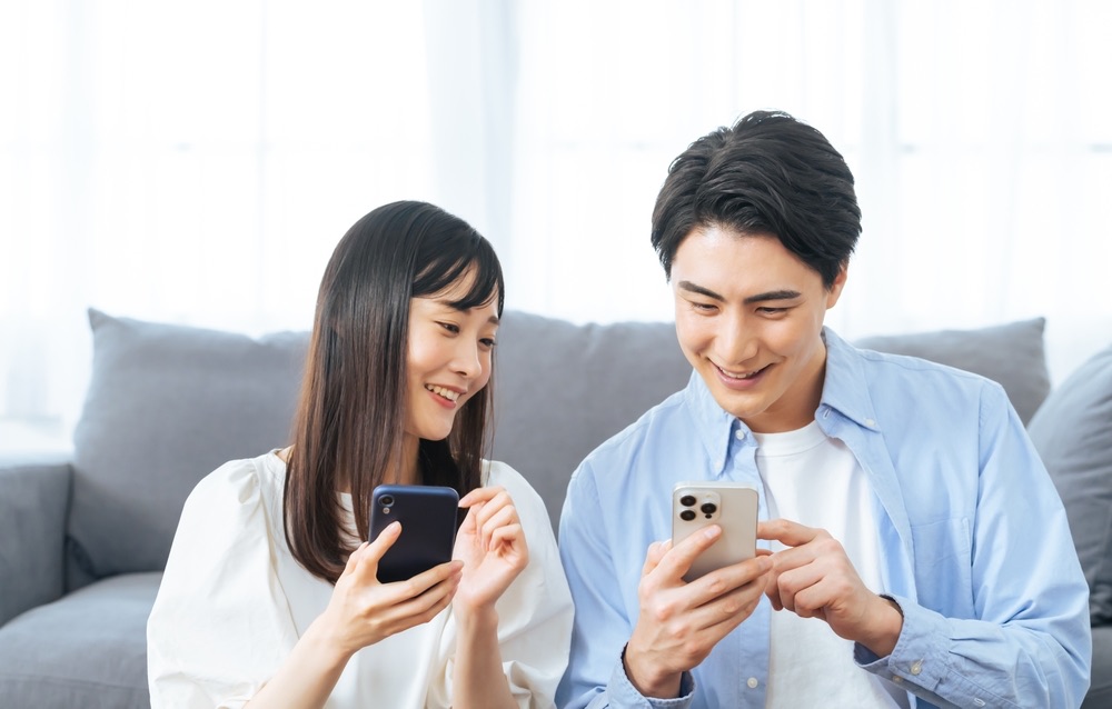スマートフォンでお互いの予定や希望を確認する日本人男女